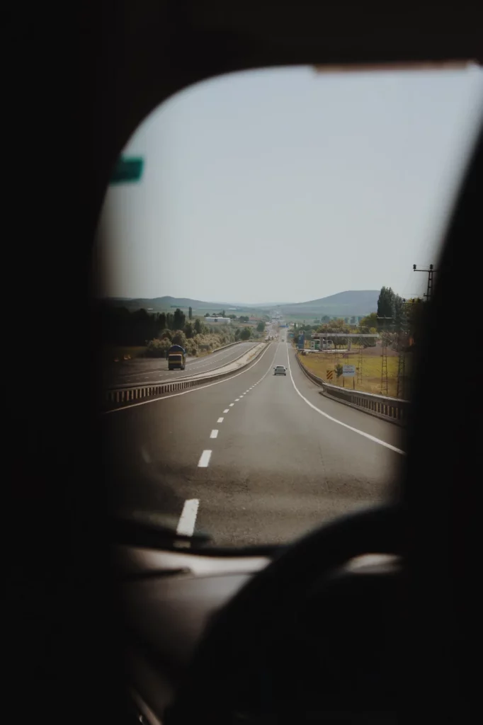 Carretera vacía vista desde la ventanilla de un coche en un viaje de vacaciones de verano