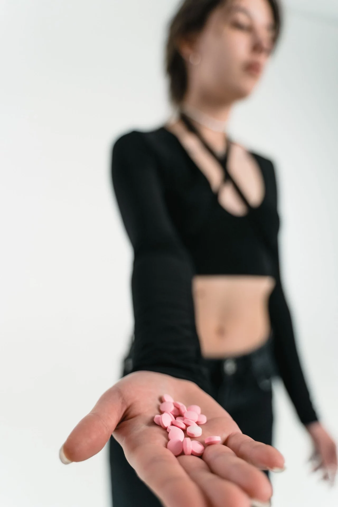 Mujer tiende la mano con pastillas